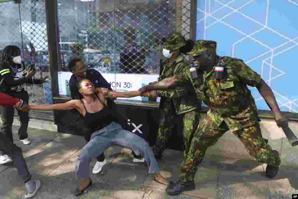 Police officers arrest a demonstrator protesting against proposed tax hikes in a finance bill that is due to be tabled in parliament in Nairobi, Kenya.