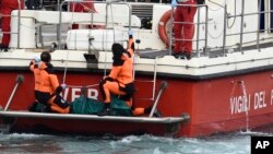 Italian firefighter scuba divers bring ashore in a green bag the body of one of the victims in the sinking of the British-flagged vessel Bayesian, Aug. 21, 2024.