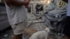 FILE — Israelis inspect the rubble of a building a day after it was hit by a rocket fired from the Gaza Strip, in Tel Aviv, Israel, Oct. 8, 2023. Chinese migrant workers in Israel were among those caught up in the middle of airstrikes launched by Hamas.