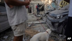 FILE — Israelis inspect the rubble of a building a day after it was hit by a rocket fired from the Gaza Strip, in Tel Aviv, Israel, Oct. 8, 2023. Chinese migrant workers in Israel were among those caught up in the middle of airstrikes launched by Hamas.