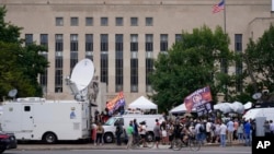Media and protesters gather at the E. Barrett Prettyman U.S. Federal Courthouse, in Washington, Aug. 3, 2023, ahead of former President Trump's arraignment on charges of having tried to overturn the results of the 2020 election in his favor. 
