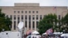 Los medios y los manifestantes se reúnen en el Edificio de la Corte Federal de EEUU E. Barrett Prettyman, en Washington, el 3 de agosto de 2023.