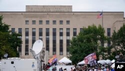 Los medios y los manifestantes se reúnen en el Edificio de la Corte Federal de EEUU E. Barrett Prettyman, en Washington, el 3 de agosto de 2023.