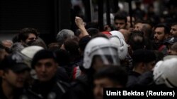 Seorang peserta aksi protes mengacungkan tinjunya saat dihadang oleh polisi Turki sambil berunjuk rasa di Lapangan Taksim untuk memperingati Hari Buruh di Istanbul, Turki, 1 Mei 2024. (Foto: REUTERS/Umit Bektas)