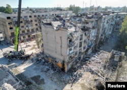 Rescuers work with heavy machinery at the site of a building destroyed during a Russian missile strike in Pokrovsk, Donetsk region, Ukraine, Aug. 8, 2023.