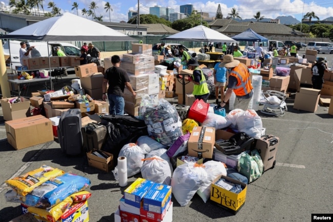 Los estibadores en Hawái y otros voluntarios preparan donaciones para las víctimas de los incendios forestales de Maui en el Muelle 1, donde las enviarán a Maui la próxima semana, en Honolulu, Hawái, el 12 de agosto de 2023.