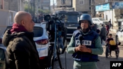 အစ္စရေးနဲ့ ဟာမတ်စ်အဖွဲ့ကြားစစ်ပွဲတွေအတွင်း ဂါဇာကမ်းမြောင်က နယ်စပ်ရာဖာမြို့ လမ်းပေါ်မှာ သတင်းတင်ဆက်နေတဲ့ သတင်းထောက်များ (ဒီဇင်ဘာ ၁၁၊ ၂၀၂၃)