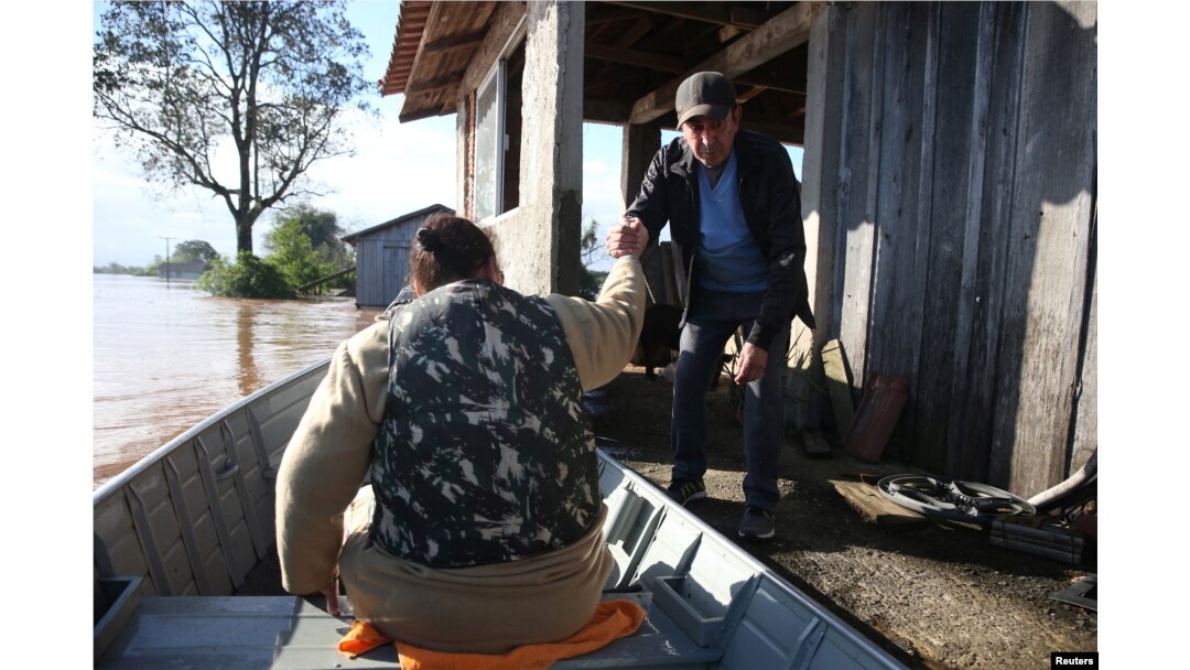 Ljudi se ukrcavaju u čamac napuštajući potopljenu kuću, tokom ciklona koji je pogodio južni grad Venansio Ajres, u državi Rio Grande do Sul, u Brazilu, 5. septembra 2023.