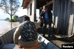 Warga dievakuasi dengan perahu saat meninggalkan rumah mereka yang terendam banjir di Venancio Aires, negara bagian Rio Grande do Sul, Brazil, 5 September 2023.