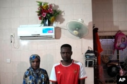 Morwan Mohammad dan istrinya Nagad Daoud Abdallah, yang melarikan diri dari perang di Sudan, berfoto di tempat penampungan pengungsi, di Batam, 16 Mei 2024. Mereka menunggu dimukimkan kembali di negara ketiga. (AP/Dita Alangkara)