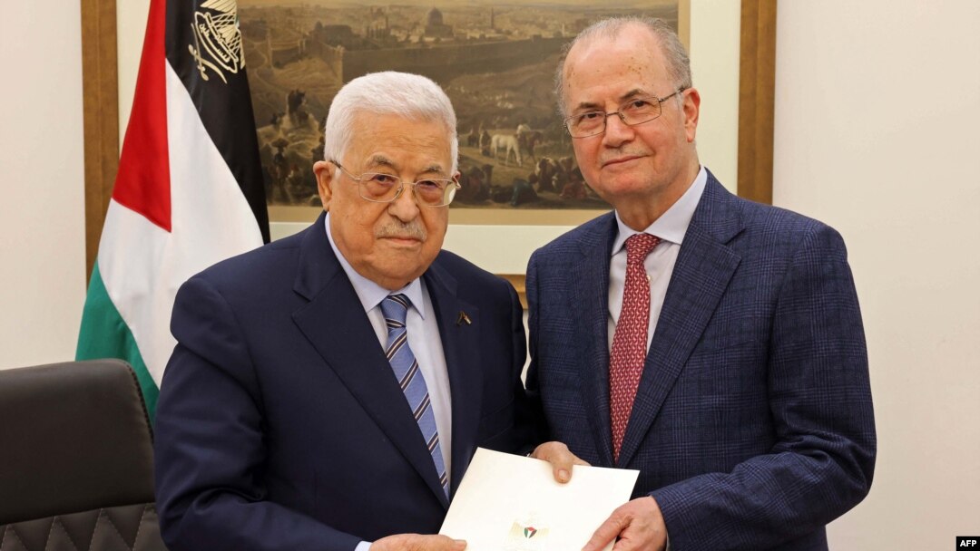 This handout picture provided by the Palestinian Authority's press office shows Palestinian President Mahmoud Abbas, left, with the newly appointed Palestinian prime minister, Mohammad Mustafa, in Ramallah on March 14, 2024. 
