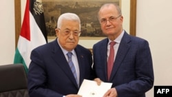 This handout picture provided by the Palestinian Authority's press office shows Palestinian President Mahmoud Abbas, left, with the newly appointed Palestinian prime minister, Mohammad Mustafa, in Ramallah on March 14, 2024. 