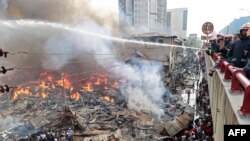 অগ্নিনির্বাপক কর্মীরা ঢাকার বঙ্গবাজার মার্কেটে আগুন নেভানোর চেষ্টা করছেন৷ ৪এপ্রিল, ২০২৩। ছবি- এএফপি