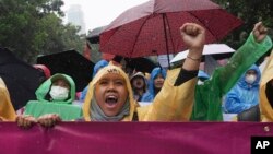 Women activists shout during a rally celebrating International Women's Day in Jakarta, Indonesia, March 8, 2023.