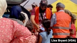 Moroccan volunteers hand out socks to children in one of the area's impacted by the earthquake that hit the country on Sept. 8, killing nearly 3,000 people and destroying homes, hospitals and schools.