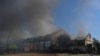 Petugas pemadam kebakaran dan polisi berusaha memadamkan api di sebuah gudang yang hangus terbakar akibat serangan pasukan Rusia di Kherson, Ukraina, pada 19 September 2023. (Foto: Reuters/Ivan Antypenko)