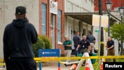Law enforcement officers walk through the crime scene, a day after a shooting at a teenager's birthday party in a dance studio, in Dadeville, Alabama, Apr.16, 2023. 