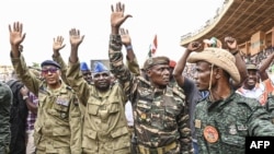 FILE - Nigerien military leaders wave to supporters at the General Seyni Kountche Stadium in Niamey, Niger, Aug. 26, 2023. 