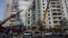 Petugas pemadam kebakaran bekerja untuk memadamkan api setelah serangan Rusia di sebuah bangunan perumahan di Uman, Ukraina tengah, Jumat, 28 April 2023. (Foto: AP/Bernat Armangue)