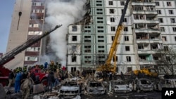 Petugas pemadam kebakaran bekerja untuk memadamkan api setelah serangan Rusia di sebuah bangunan perumahan di Uman, Ukraina tengah, Jumat, 28 April 2023. (Foto: AP/Bernat Armangue)