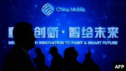 参观者在西班牙巴塞罗那举行的2023年世界移动通信大会期间走过中国国企“中国移动”的标识。(2023年2月28日)