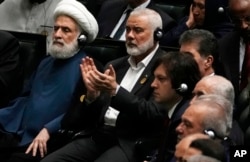 Hamas chief Ismail Haniyeh claps as newly elected Iranian President Masoud Pezeshkian speaks while deputy leader of Hezbollah, Sheikh Naim Kassem, left, sits during the swearing-in ceremony of Pezeshkian in Tehran, Iran, July 30, 2024.