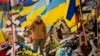 A Ukrainian serviceman salutes standing between the graves of soldiers during the funeral of Hennadii Kovshyk, who was killed on the frontline in eastern Ukraine, in Kharkiv, Ukraine, Feb. 16, 2023.