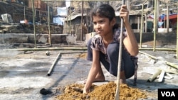 Sofiya Khatun, an 11-year-old Rohingya girl, is helping build her family’s new shanty at Balukhali area of the refugee camp after it was destroyed by fire. (Noor Hossain/VOA)