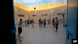 FILE - Prisoners play volleyball, in a Kurdish-run prison housing former members of the Islamic State group, in Qamishli, north Syria, April 3, 2018.