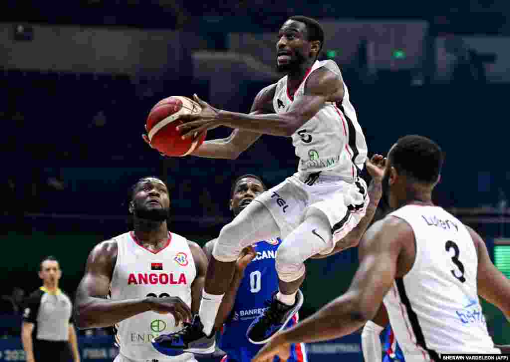 O angolano Childe Dundao (ao centro) domina a bola em jogo do grupo A, do Mundial do Basquetebol. Araneta Coliseum, Quezon City, Manila. 29 agosto 2023