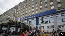 Ukrainian army veterans rest with their families and comrades outside St. Panteleimon hospital in Lviv, Ukraine, July 25, 2023. Ukraine is facing the prospect of a future with upwards of 20,000 amputees.