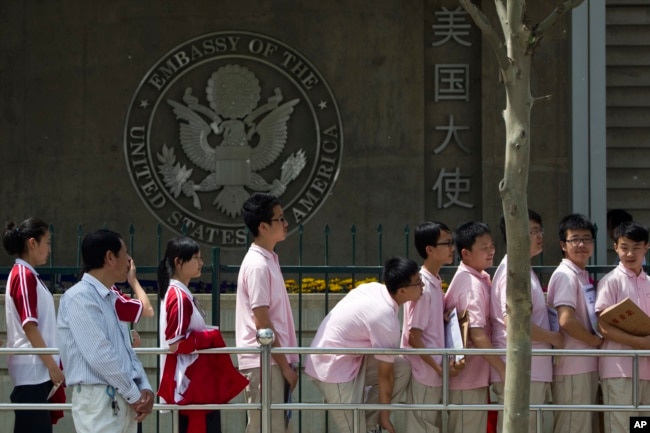 FILE - Chinese students wait outside the U.S. Embassy for their visa application interviews on May 2, 2012, in Beijing. (AP Photo/Alexander F. Yuan, File)