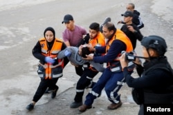 Medics carry an injured person during an Israeli military raid in Jenin, in the Israeli-occupied West Bank, Dec. 12, 2023.