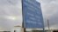 FILE - A woman walks by a sign at the U.N.-controlled buffer zone near Larnaca, Cyprus, on Jan. 8, 2009. Three U.N. soldiers had to be treated for minor injuries after Turkish Cypriots attacked peacekeepers who obstructed crews working on a road that would encroach on the zone.