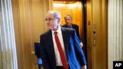 FILE - Sen. James Risch, R-Idaho, center, a member of the Senate Foreign Relations Committee, and Sen. Dan Coats, R-Ind., head to the chamber to advance a bill providing $1 billion in loan guarantees to Ukraine, at the Capitol in Washington, Monday, March 24, 2014.