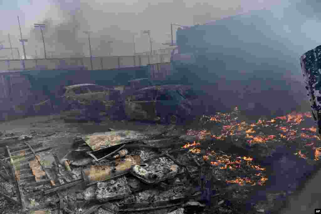 Flames burn at a business during a fire in northern Athens as hundreds of firefighters tackle a major wildfire raging out of control on fringes of Greek capital.