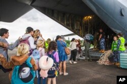 In this photo provided by the Australian Department of Defense, Australian and other tourists board an Australian Airforce Hercules as they prepare to depart from Magenta Airport in Noumea, New Caledonia, May 21, 2024.