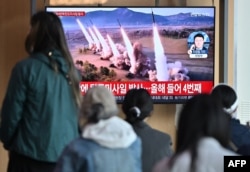 22일 한국 서울역에서 시민들이 북한의 미사일 시험 발사 관련 뉴스를 시청하고 있다.