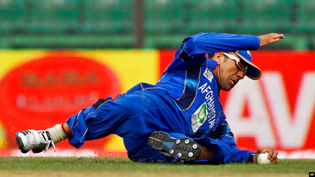 FILE - Afghanistan's Karim Sadiq dives to catch the ball while fielding during the Asia Cup one-day international cricket tournament against Pakistan in Fatullah, near Dhaka, Bangladesh, Feb. 27, 2014. 