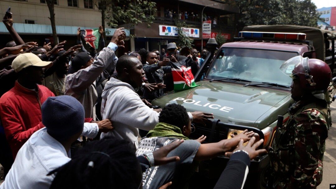 Demonstrators block a road in front of a police vehicle during a protest in Nairobi, Kenya, July 23, 2024.
