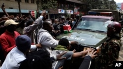 Demonstrators block a road in front of a police vehicle during a protest in Nairobi, Kenya, July 23, 2024.