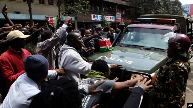 Demonstrators block a road in front of a police vehicle during a protest in Nairobi, Kenya, July 23, 2024.