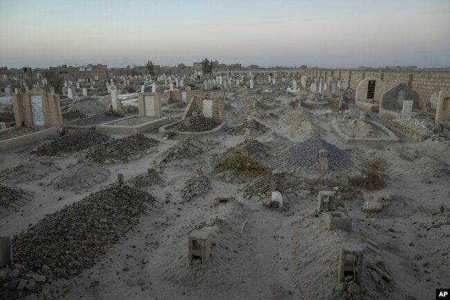 An Afghan Shiite cemetery, where a large number of Shiite migrants who were killed while trying to cross the border are buried, lies on the outskirts of Zaranj city, Afghanistan, Monday, Dec. 25, 2023. (AP Photo/Ebrahim Noroozi)