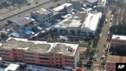 In this photo released by Xinhua News Agency, an aerial drone shows the dormitory with charred windows after a fire at the Yingcai School in Dushu Town, Fangcheng County, Nanyang city, in central China's Henan province on Jan. 20, 2024. 