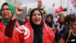 Tunisians take part in a protest against the presence of sub-Saharan migrants who have found themselves stranded as the country ramps up its border patrol efforts, in Jebeniana, Tunisia, May 18, 2024.