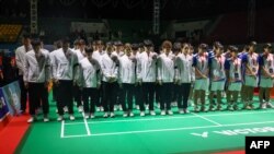 Para pebulutangkis dan pelatih China (mengenakan jaket putih dan ban lengan hitam) dan sejumlah pemain lainnya mengheningkan cipta mengenang wafatnya Zhang Zhijie, pebulutangkis junior China, di turnamen Kejuara Asia Junior di Yogyakarta, pada 1 Juli 2024. (Foto: PBSI/AFP)