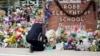 FILE - Reggie Daniels pays his respects at a memorial at Robb Elementary School, June 9, 2022, in Uvalde, Texas. The 19 fourth-graders and two teachers killed at the school were remembered May 24, 2024, on the second anniversary of the shootings. 