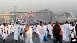 Thousands of Muslim pilgrims make their way to throw stones at a pillar