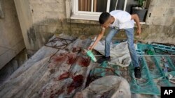 A boy looks at blood stains after a military raid in the Nur Shams refugee camp near the city of Tulkarem, in the occupied West Bank, May 6, 2023.
