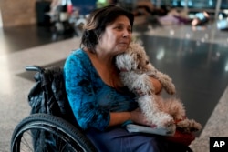 Laura Cardoso holds her dog inside the Jorge Newbery international airport, commonly known as Aeroparque, in Buenos Aires, Argentina, April 6, 2023.